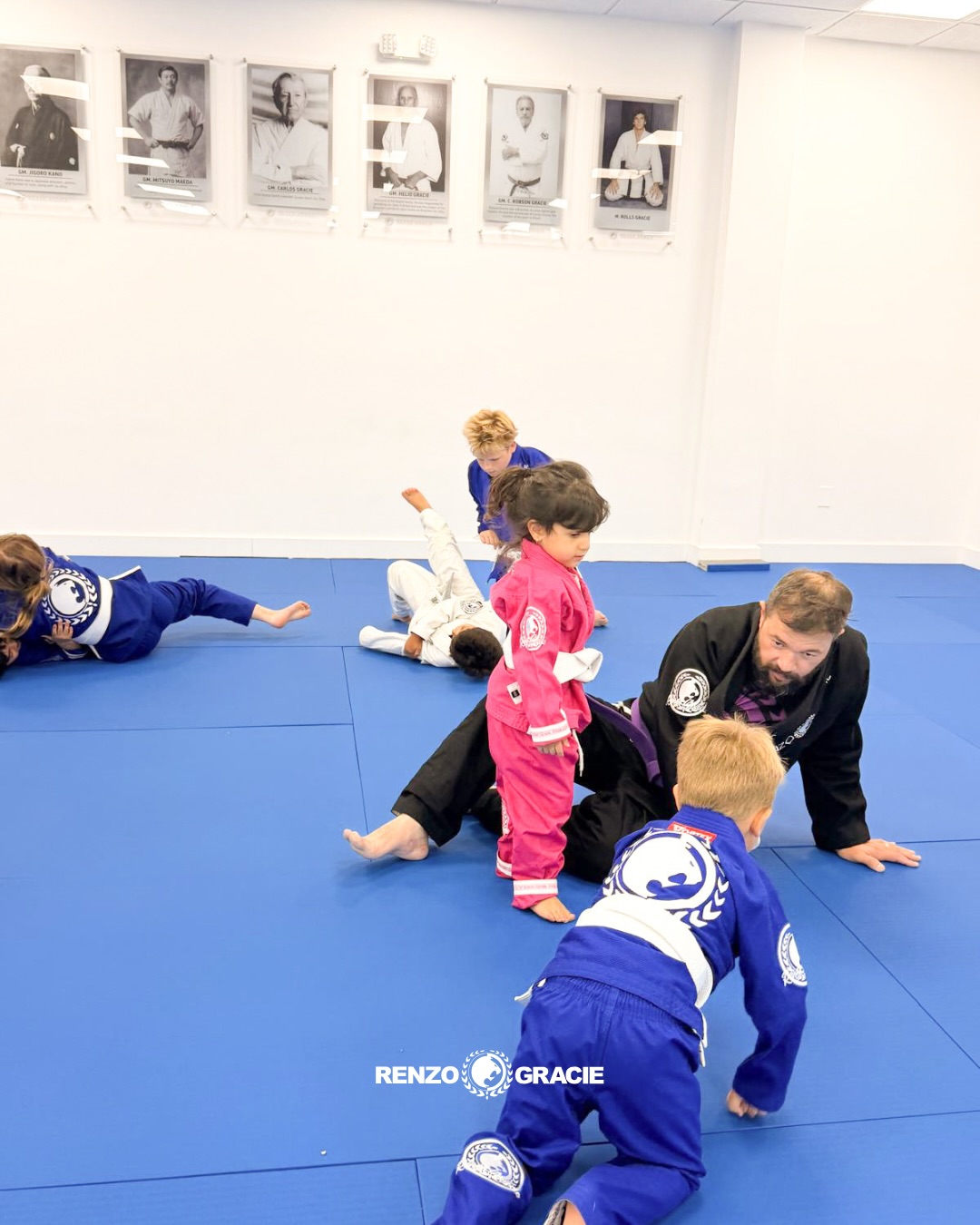 Kids in blue and pink gis training with their coach at Renzo Gracie Boynton Beach